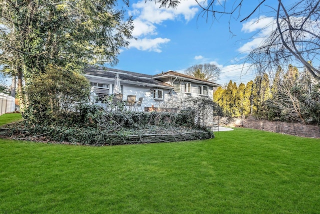 rear view of house featuring a yard