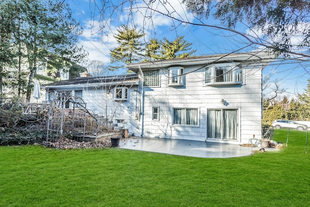 back of property featuring a lawn and a patio