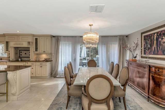 tiled dining room featuring a notable chandelier