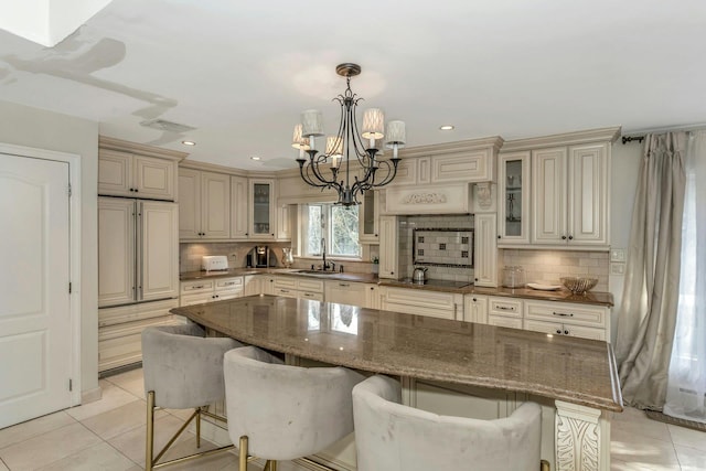 kitchen featuring hanging light fixtures, a kitchen bar, decorative backsplash, and a center island