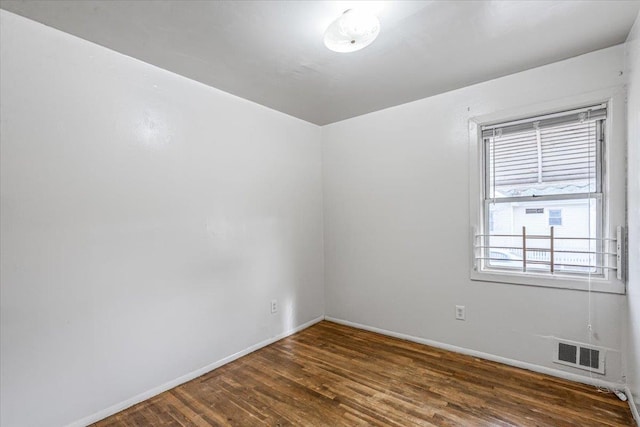 spare room with dark hardwood / wood-style flooring