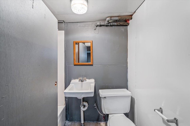 bathroom featuring toilet and a tub