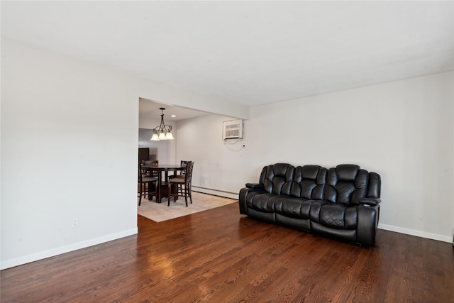 living room with hardwood / wood-style flooring, a baseboard radiator, a wall mounted AC, and a notable chandelier