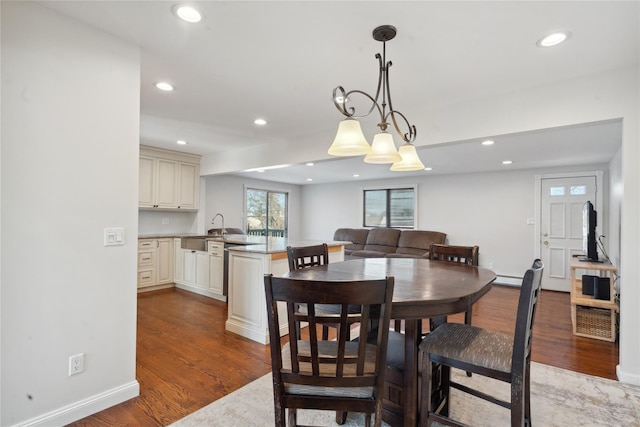 dining area featuring baseboard heating, an inviting chandelier, and hardwood / wood-style floors