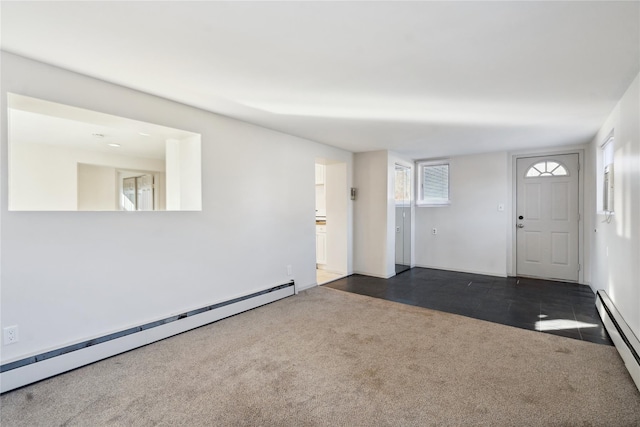 empty room with baseboard heating and dark carpet