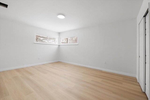 unfurnished bedroom with a closet and light wood-type flooring