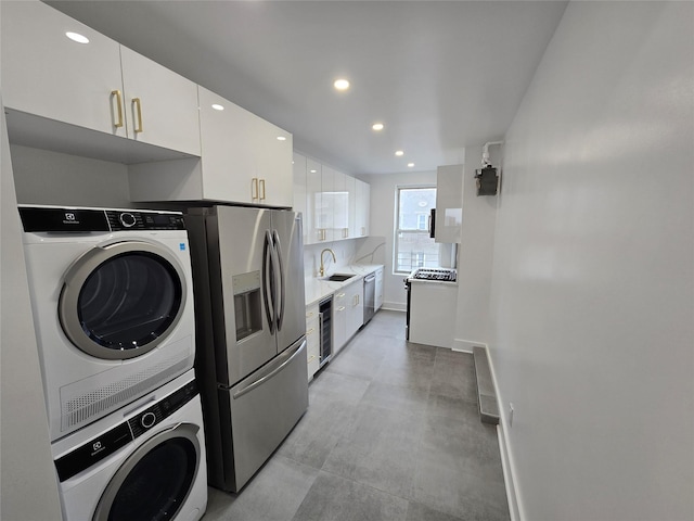 laundry room with stacked washer and clothes dryer, wine cooler, and sink