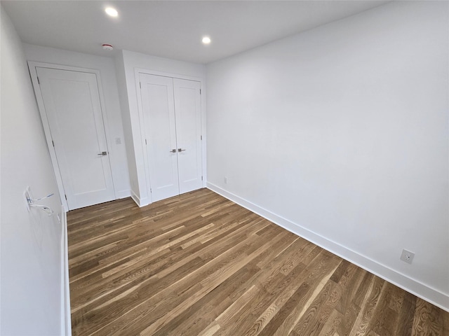 unfurnished bedroom with dark hardwood / wood-style floors and a closet