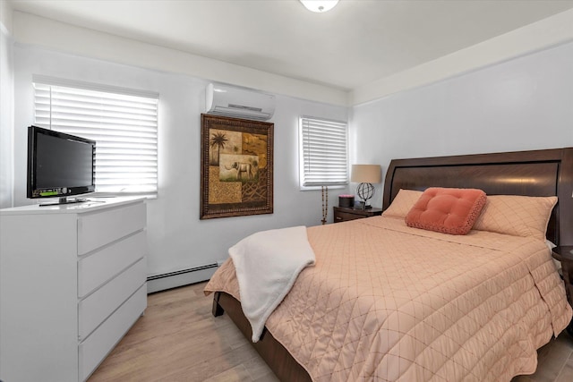 bedroom with an AC wall unit, light wood-type flooring, and a baseboard heating unit