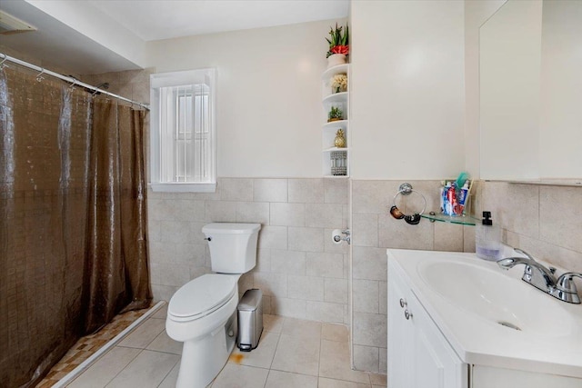 bathroom with a stall shower, wainscoting, toilet, tile patterned floors, and vanity