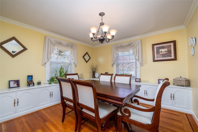 dining room with a notable chandelier, ornamental molding, and hardwood / wood-style floors