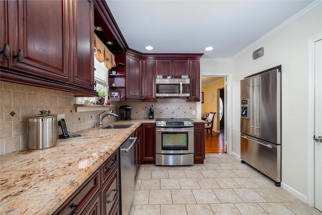 kitchen with light stone countertops, appliances with stainless steel finishes, tasteful backsplash, sink, and crown molding