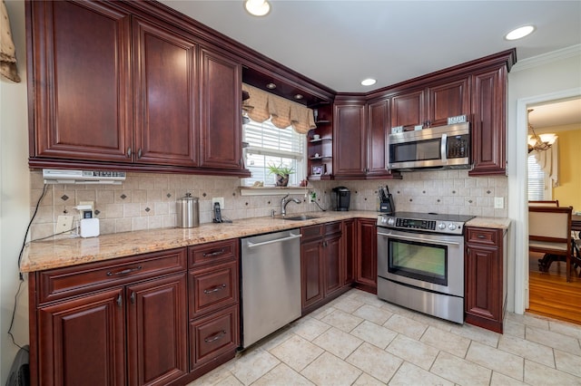 kitchen featuring backsplash, sink, light stone countertops, appliances with stainless steel finishes, and ornamental molding