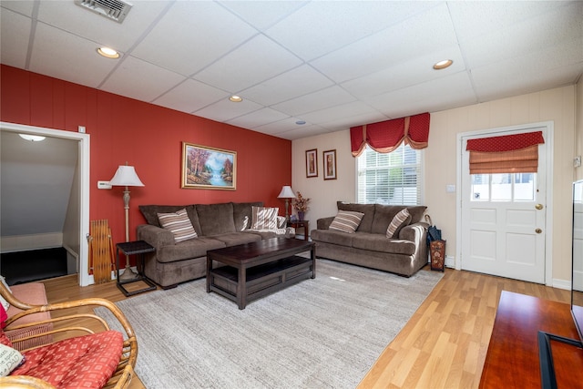 living room featuring wood-type flooring and a paneled ceiling