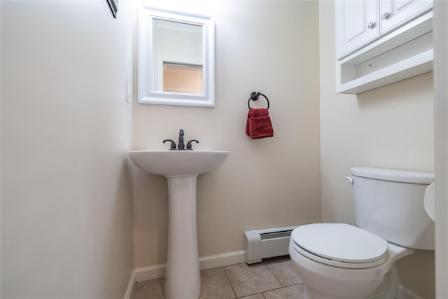 bathroom with toilet, baseboard heating, tile patterned floors, and sink