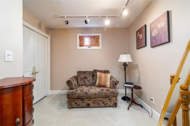 living area featuring light carpet and track lighting