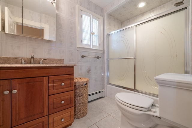 full bathroom with toilet, vanity, a baseboard heating unit, tile patterned floors, and combined bath / shower with glass door