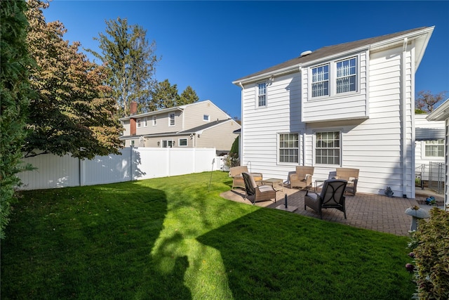 rear view of property with a lawn and a patio