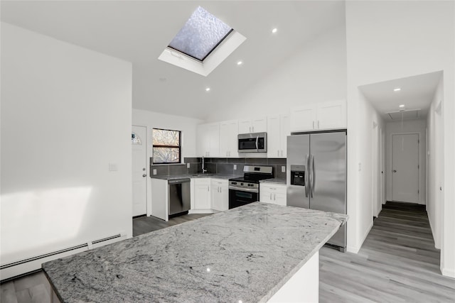 kitchen featuring a baseboard radiator, white cabinetry, light stone countertops, high vaulted ceiling, and stainless steel appliances