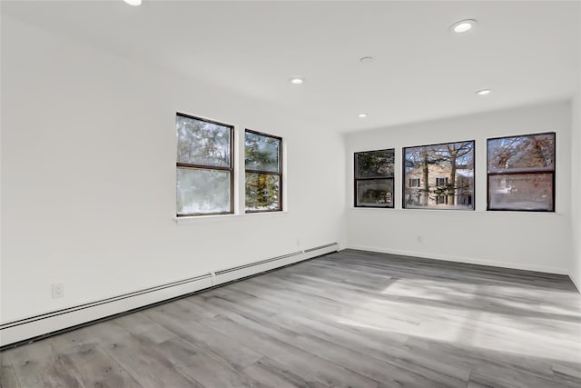 empty room featuring light hardwood / wood-style floors and a baseboard heating unit