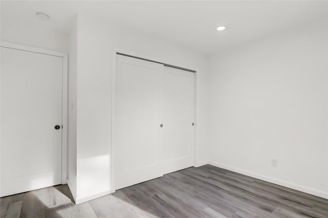 unfurnished bedroom with a closet and hardwood / wood-style flooring