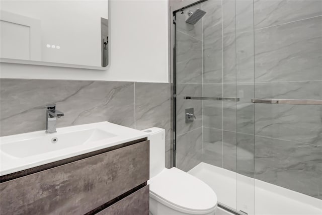 bathroom featuring toilet, tile walls, an enclosed shower, and vanity