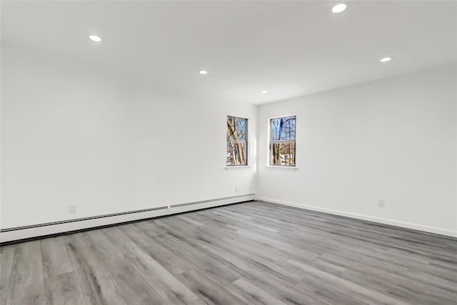 spare room featuring light hardwood / wood-style floors and a baseboard heating unit