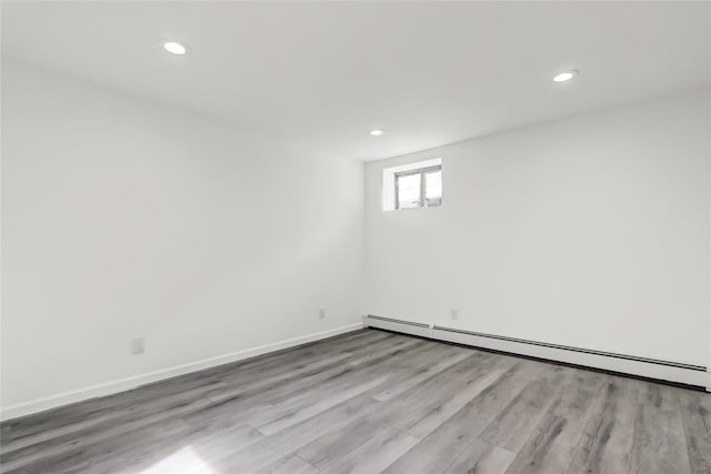 empty room with light hardwood / wood-style floors and baseboard heating