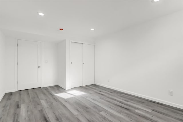 unfurnished bedroom with light hardwood / wood-style flooring and a closet