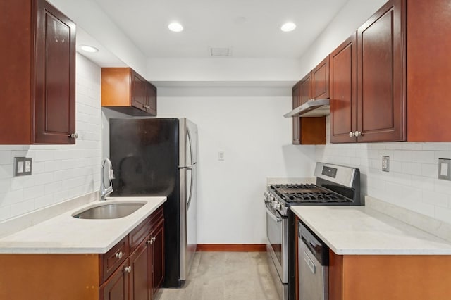 kitchen with light stone counters, appliances with stainless steel finishes, sink, and backsplash