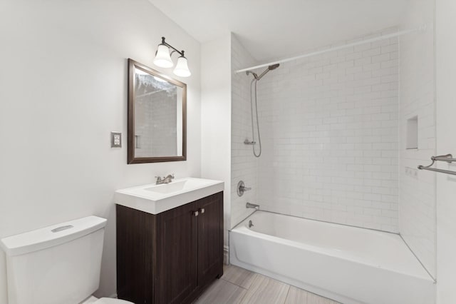 full bathroom featuring tiled shower / bath combo, vanity, and toilet