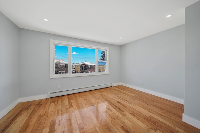 empty room featuring light hardwood / wood-style floors and a baseboard radiator