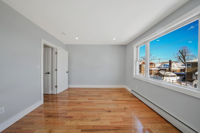 spare room with light wood-type flooring and baseboard heating