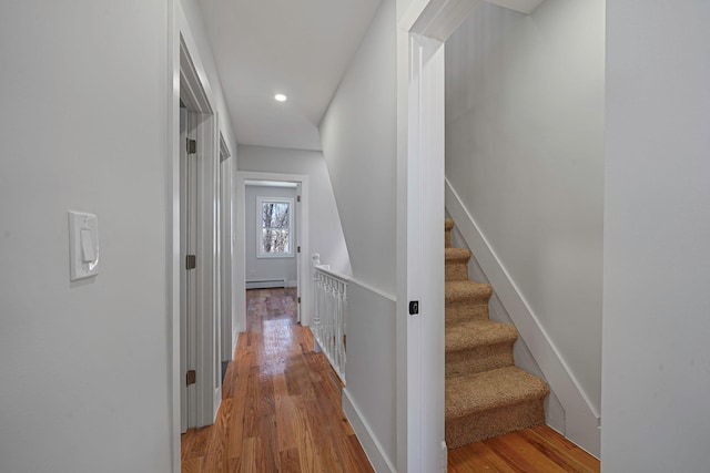 hallway featuring a baseboard heating unit and light hardwood / wood-style flooring