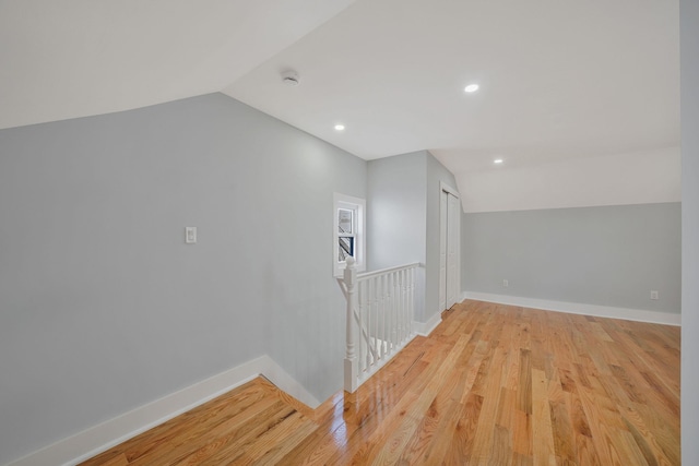 additional living space with vaulted ceiling and light wood-type flooring