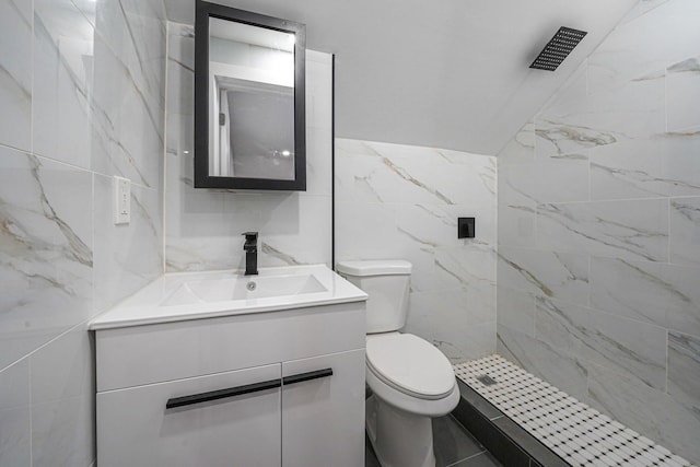 bathroom featuring toilet, tile walls, tiled shower, and vanity