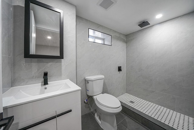 bathroom with a shower, tile walls, and toilet