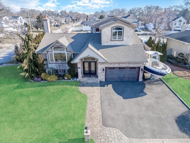 view of front of house featuring a front lawn, french doors, and a garage