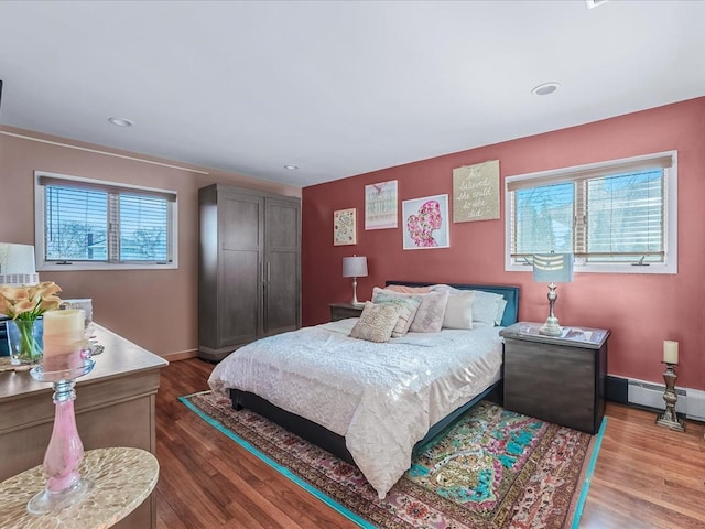 bedroom with hardwood / wood-style flooring and a baseboard radiator