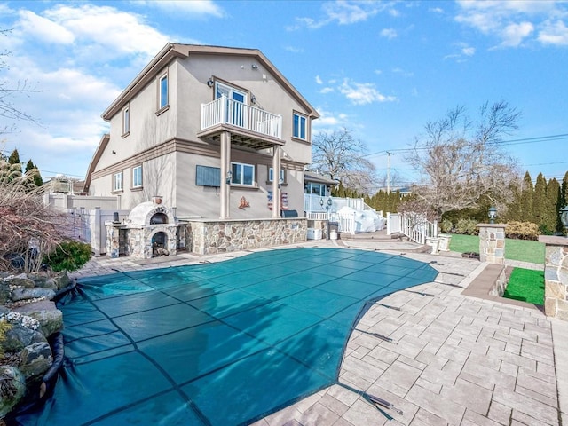 view of pool featuring a patio area and an outdoor fireplace