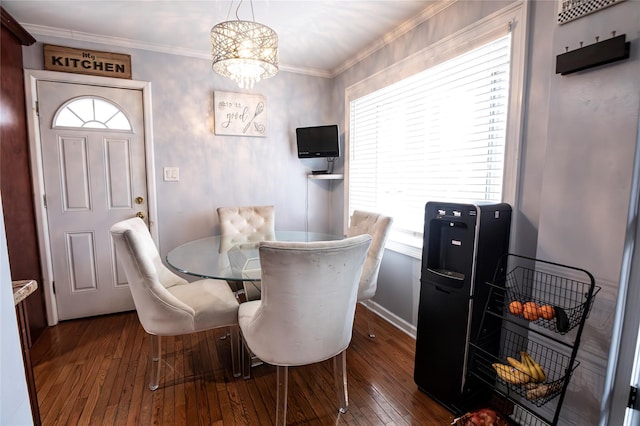 dining space with dark hardwood / wood-style flooring, ornamental molding, and a chandelier