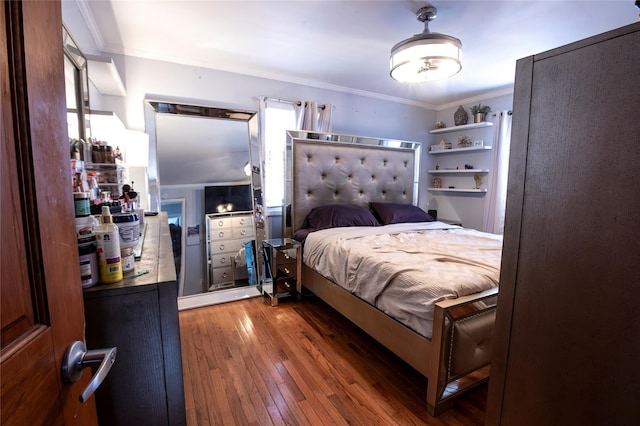 bedroom with dark hardwood / wood-style flooring and crown molding