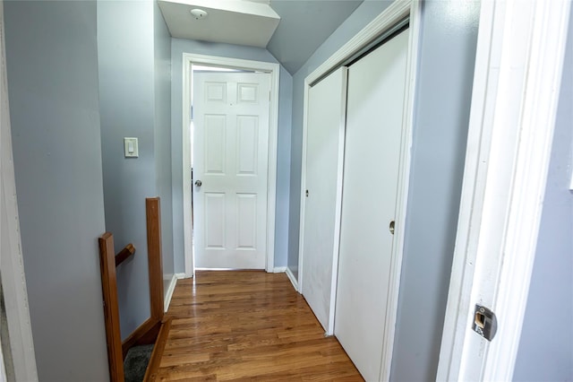 hall with vaulted ceiling and hardwood / wood-style flooring