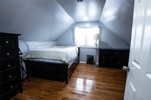 bedroom with dark hardwood / wood-style floors, radiator, and vaulted ceiling