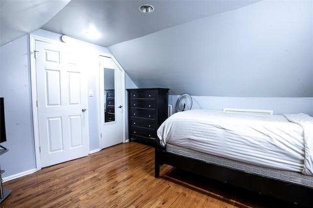 bedroom featuring vaulted ceiling and dark hardwood / wood-style flooring