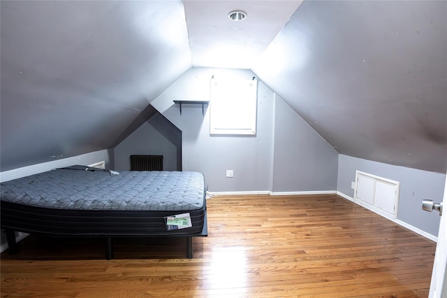 bedroom featuring light hardwood / wood-style floors and vaulted ceiling