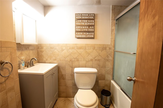 full bathroom with toilet, tile walls, shower / bath combination with glass door, and tile patterned flooring