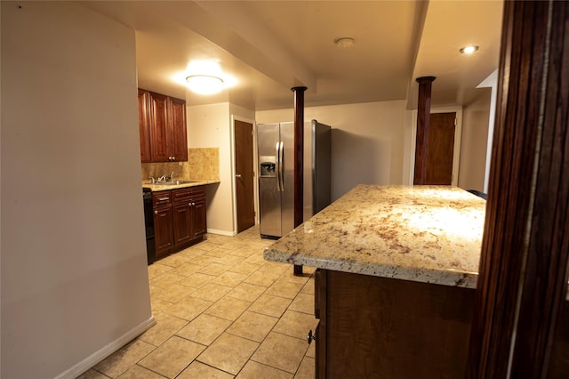 kitchen with stainless steel refrigerator with ice dispenser, decorative backsplash, and sink