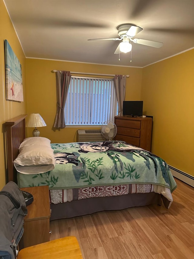 bedroom featuring a baseboard heating unit, ceiling fan, hardwood / wood-style floors, and radiator heating unit