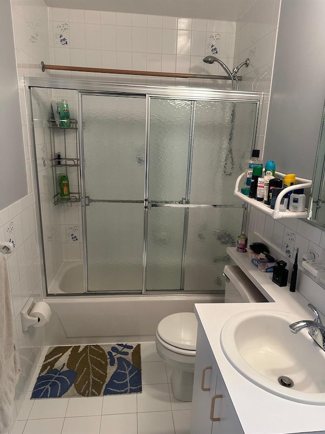 full bathroom with enclosed tub / shower combo, tile patterned floors, vanity, and toilet